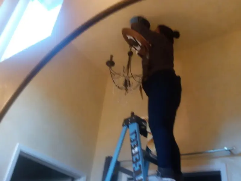 Electrician installing a chandelier in a High Bridge residence